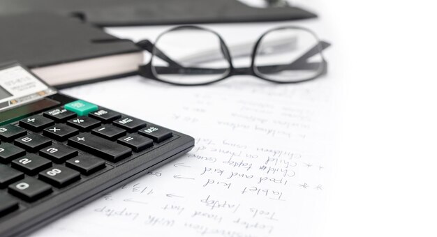 High angle view of eyeglasses with calculator with document on table