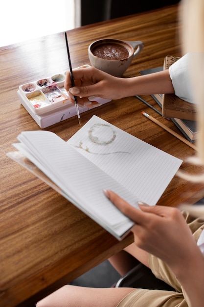 high angle woman journaling with paint