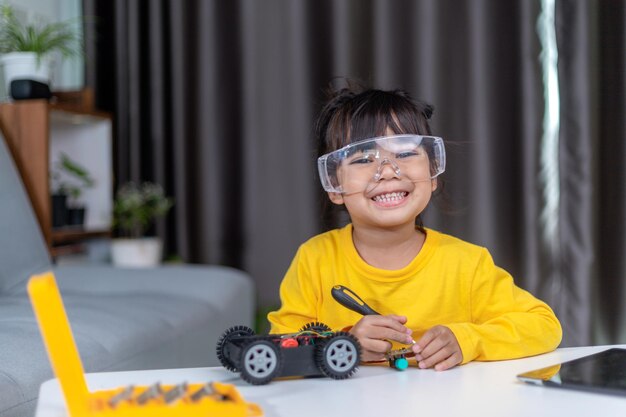 Inventive kid constructing robot cars at home