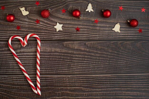 Karanlık ahşap bir arka planda Noel aksesuarları ve şeker lolipopundan kalp Metin için alan
