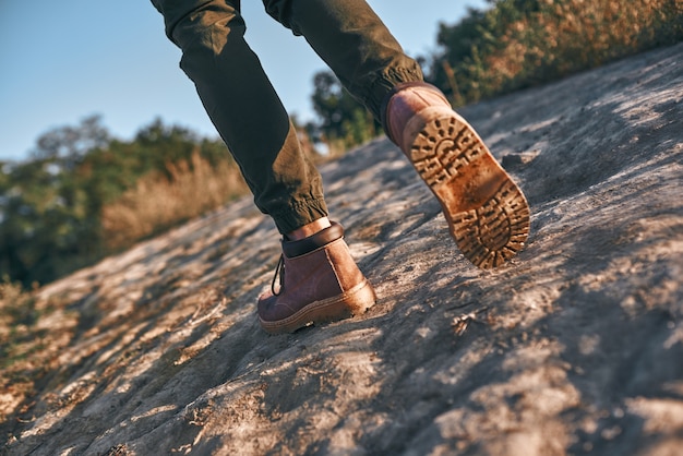 Legs of young tourist blogger what walks at mountains cropped photo