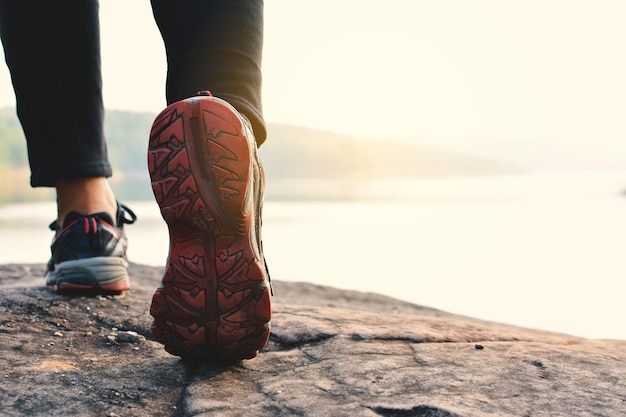 Low section of person walking at lakeshore