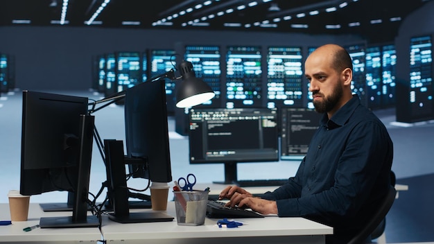 man programming in high tech facility with server rows