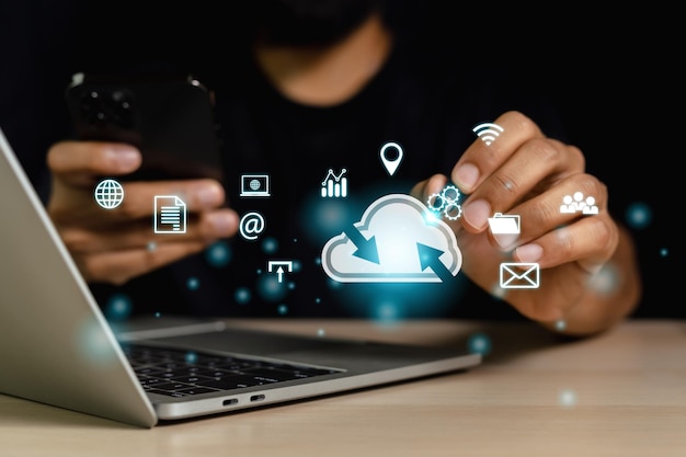 Man using laptop holding pen finger point at data cloud icons.