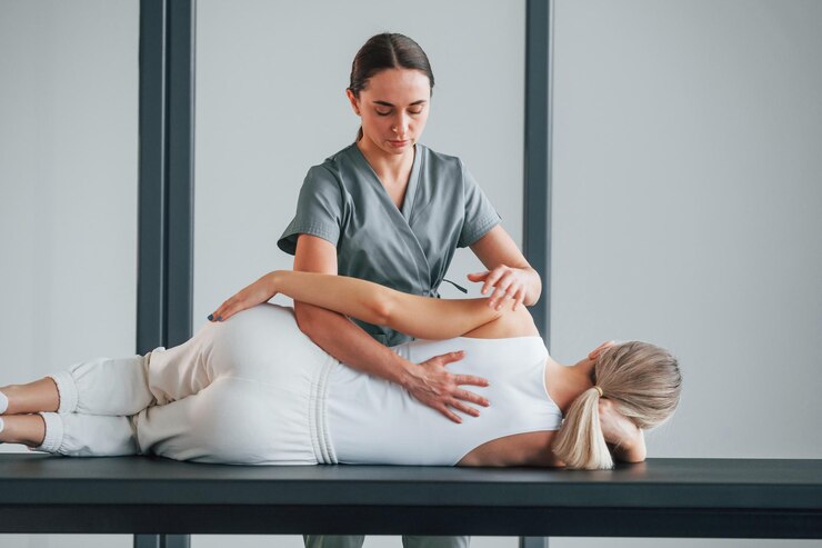 Fotoğraf massaging the back woman is in health center getting help by doctor