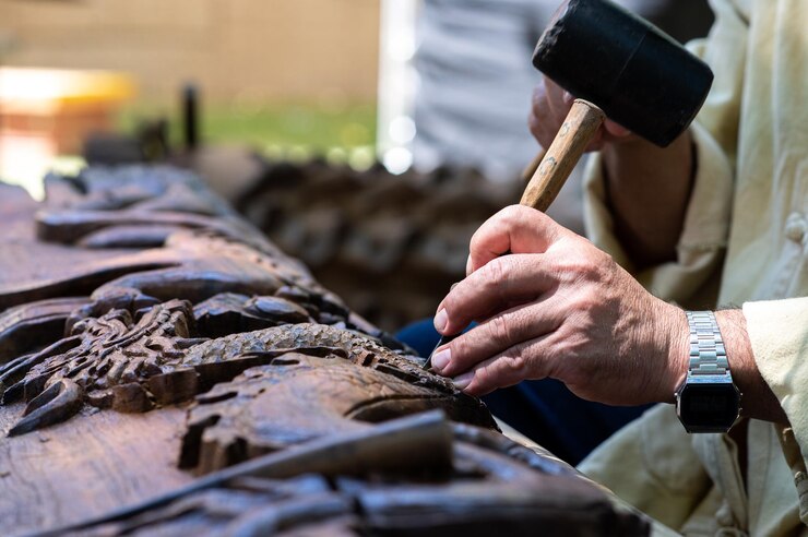 Fotoğraf midsection of artist carving design on wood