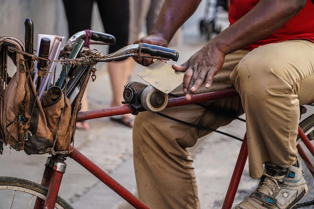 midsection of knife sharpener sitting on bicycle