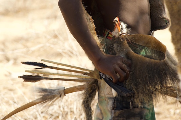 Midsection of man carrying bird while walking on field