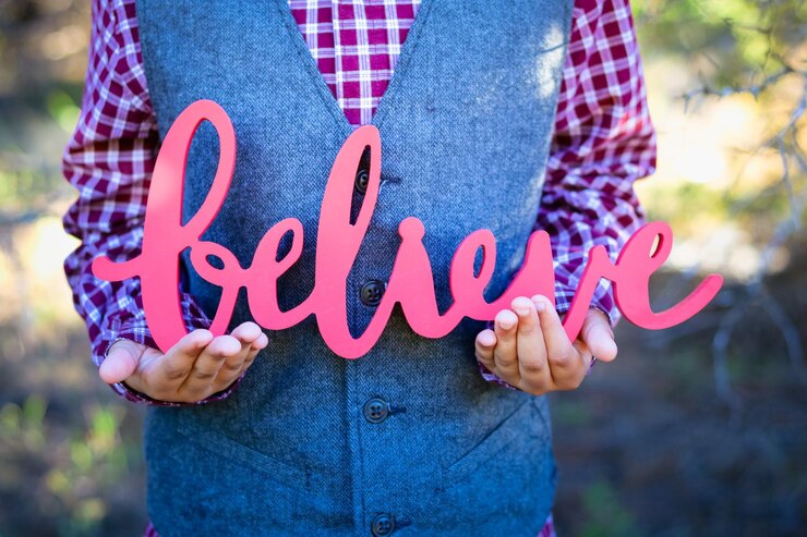 Fotoğraf midsection of man holding believe text outdoors