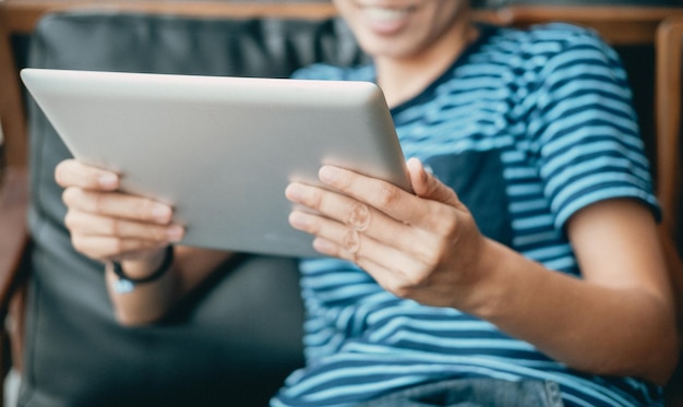 Midsection of woman holding digital tablet