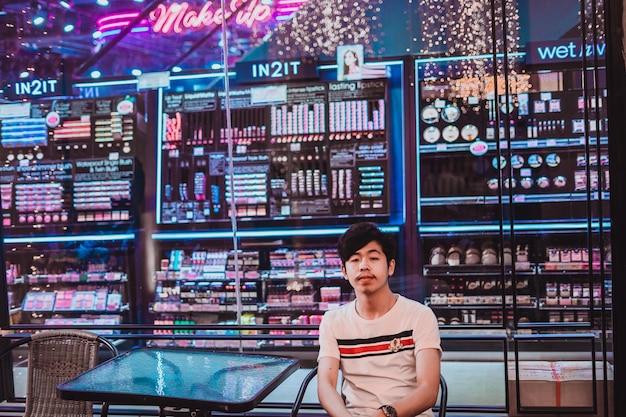 portrait of smiling young man sitting at sidewalk cafe