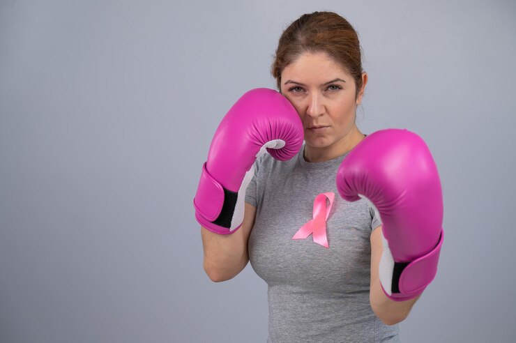 Fotoğraf portrait of woman holding red boxing gloves against white background