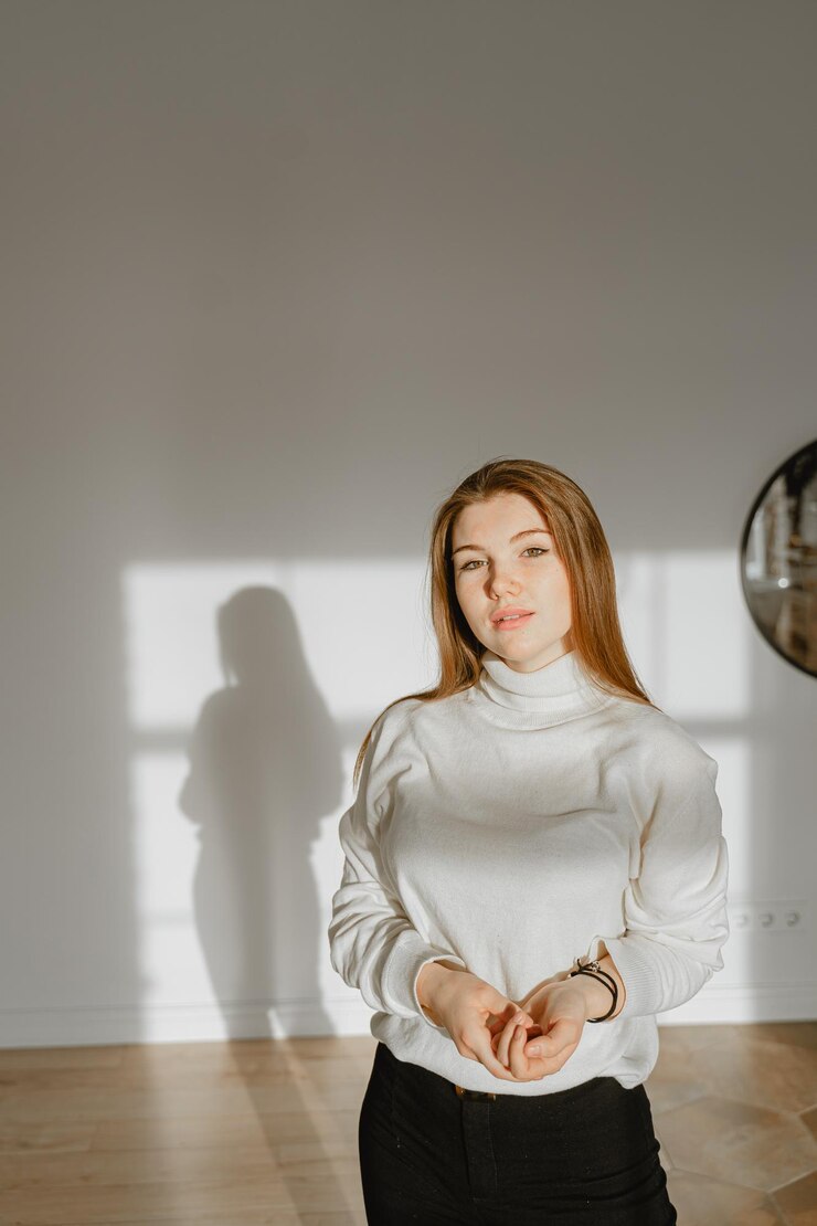Fotoğraf portrait of young woman standing against wall