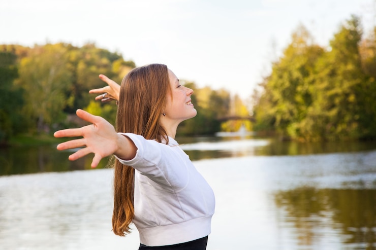 Fotoğraf profile. cheerful young adult girl posing near lake. autumn, yellow, fall. outdoor shot