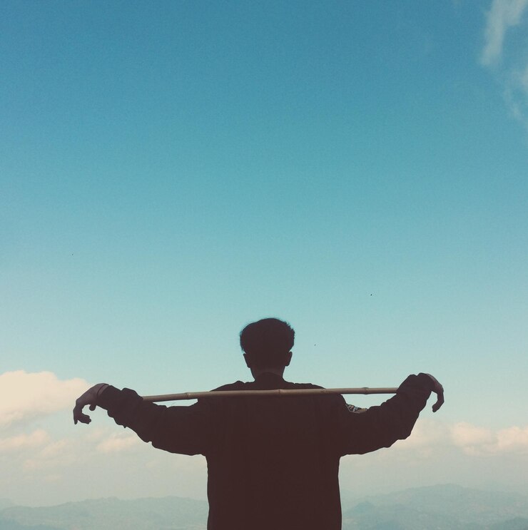 Fotoğraf rear view of man standing against blue sky