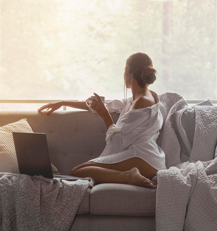 Fotoğraf rear view of woman sitting on sofa at home