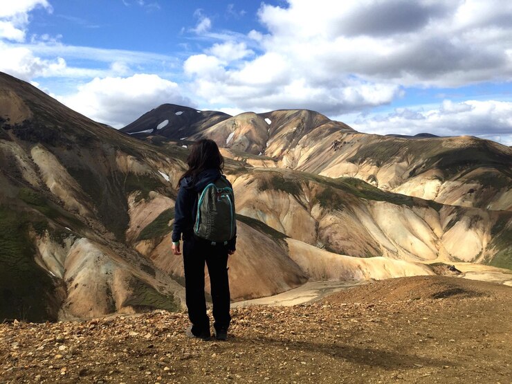 Fotoğraf rear view of woman standing on field against mountain range