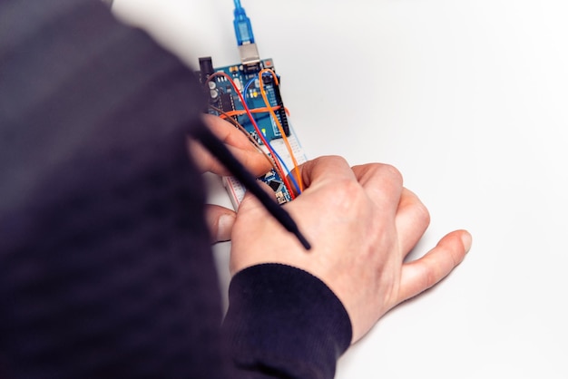 Robotics Man makes a robot Modern technologies Development of automated technical systems A mechanic is assembling a robot Closeup Stem Concept