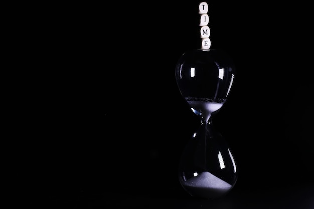 Sand running through the bulbs of an hourglass measuring the passing time i