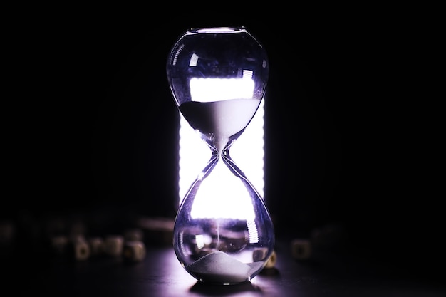 Sand running through the bulbs of an hourglass measuring the passing time in a countdown