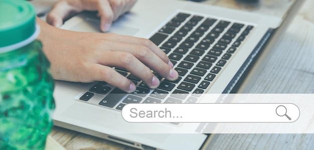 Searching data on internet concept working at laptop on desk finding information online search bar