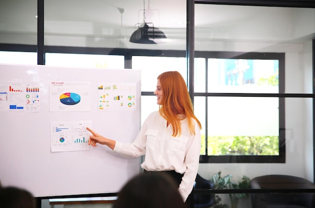 Shot of a mature businesswoman sitting and training her team in the office