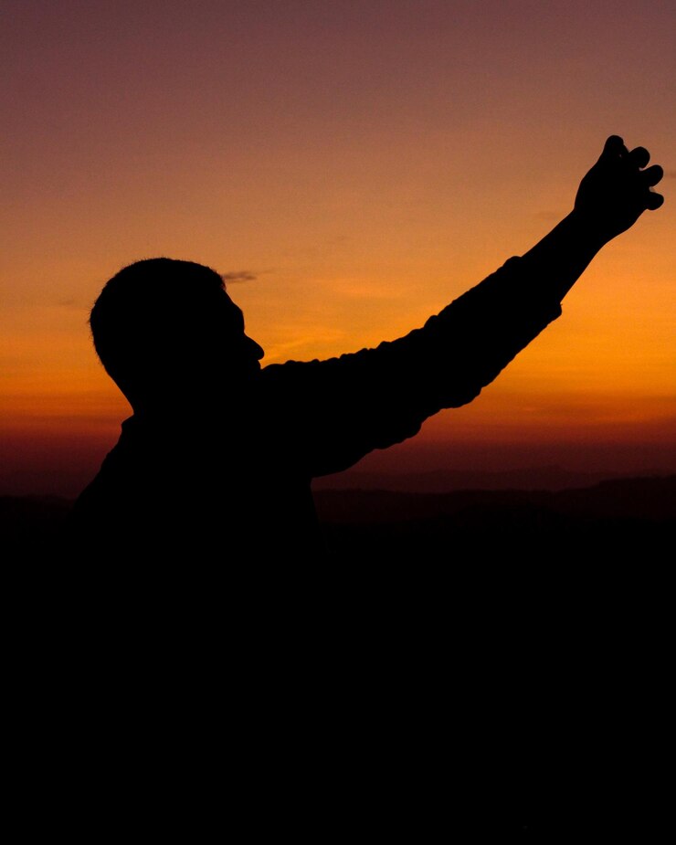 Fotoğraf silhouette people standing against orange sky during sunset