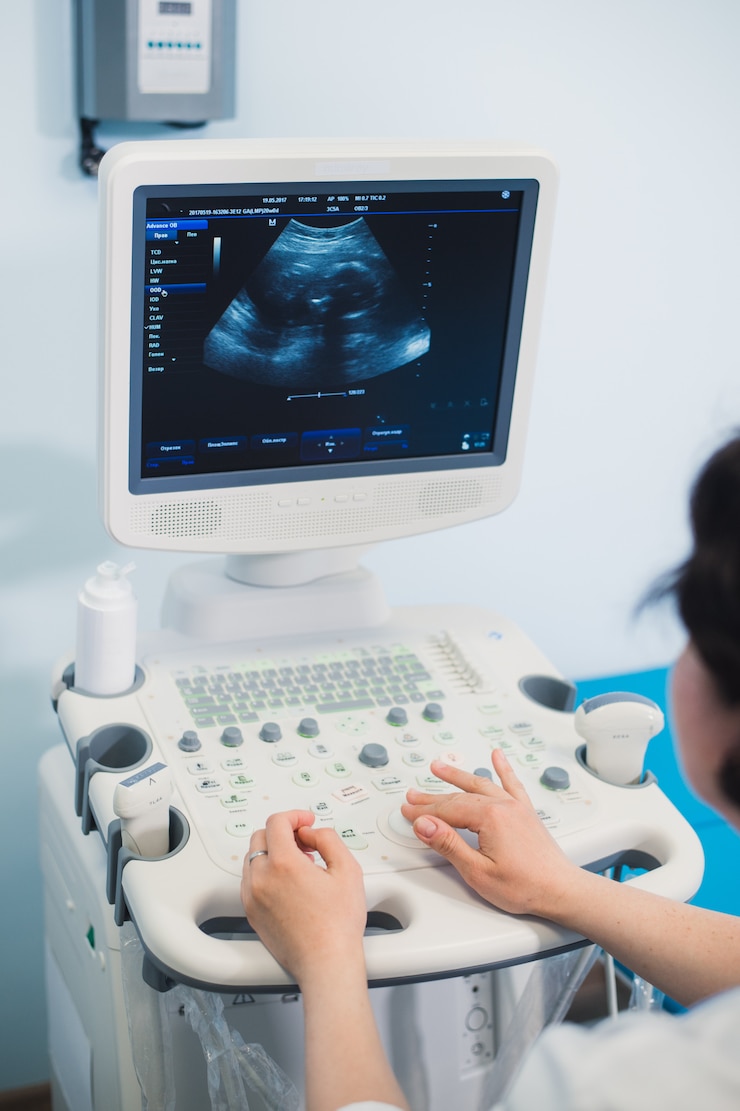 Fotoğraf skillful sonographer using ultrasound machine at work
