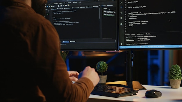 software engineer typing on keyboard buttons writing lines of code close up