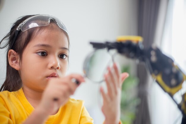 STEM education concept Asian students learn at home by coding robot arms in STEM mathematics engineering science technology computer code in robotics for kids concepts