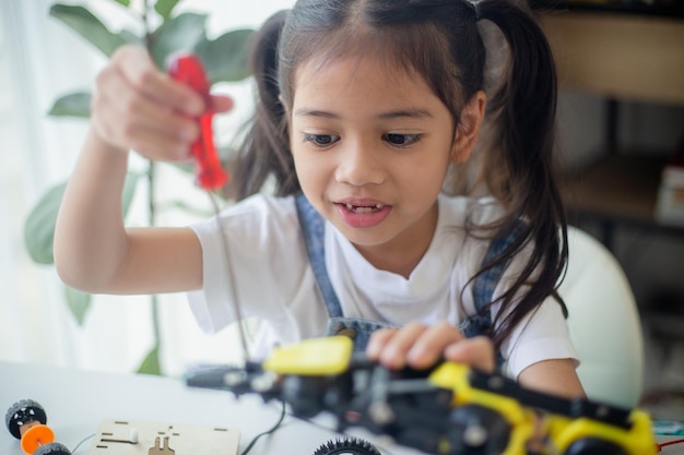 STEM education concept Asian young girl learning robot design