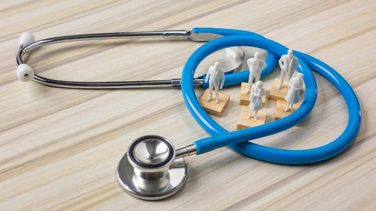 Fotoğraf stethoscope and human figurines on table