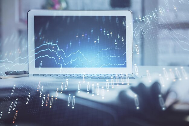 Stock market graph on background with desk and personal computer Multi exposure Concept of financial analysis
