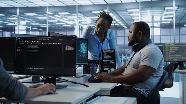 Team of technicians using PC to check for system failures in data center