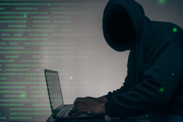 The hacker was wearing a black hoodie Stealing huge financial data on computers with binary code