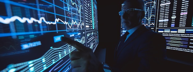 the man working on the big sensor display in the dark lab