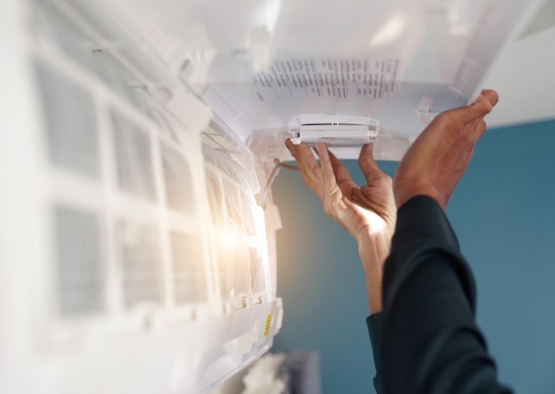 The worker cleans and repairs the air conditioner to ensure it operates properly