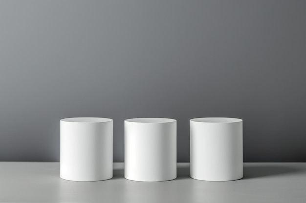Three white cylinders on a gray background Mockup for design
