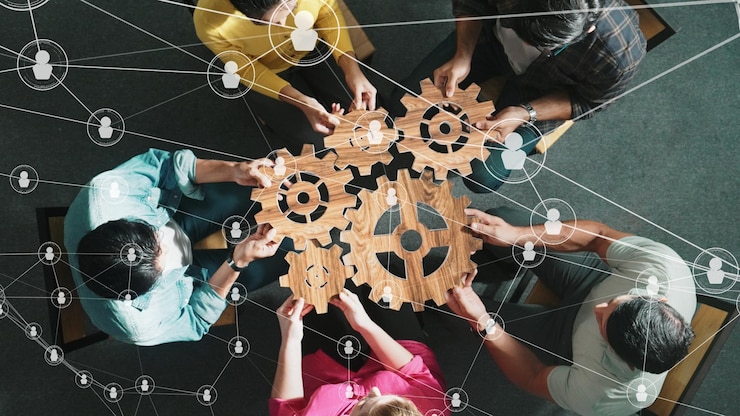 Fotoğraf top view of smart business people joining and gathering wooden gear symposium