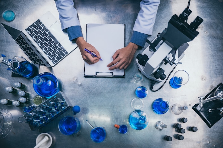 Fotoğraf top view workspace in laboratory with microscope, laptop, and laboratory tools