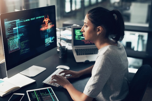 Typing woman and hacker computer programmer or coder hacking data IT focus and female developer engineer or person programming coding and writing software for phishing cyber security or virus