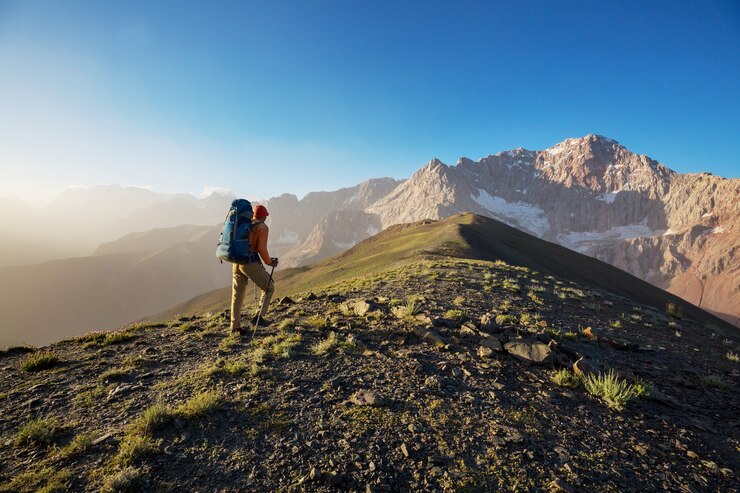 Fotoğraf wanderlust time. man hiking in beautiful fann mountains in pamir, tajikistan. central asia.