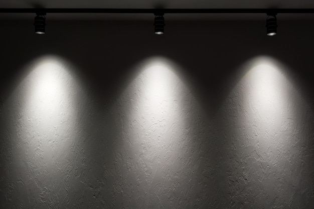White wall with track light Spotlight beams on the wall Dark background