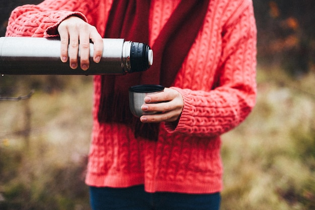 woman drinking hot beverage outdoors