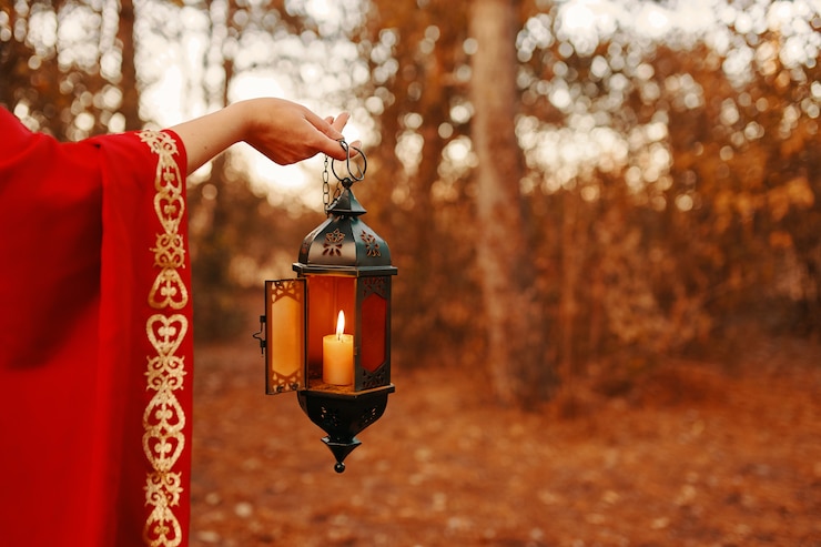 Fotoğraf woman holding a lantern with a candle in the forest