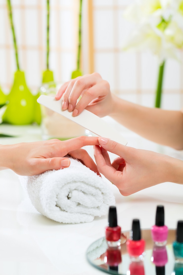 Fotoğraf woman in nail salon receiving manicure