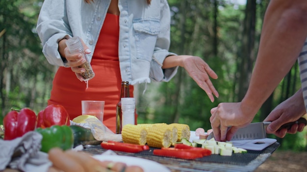woman seasoning picnic vegetables cooking in forest closeup girl preparing food