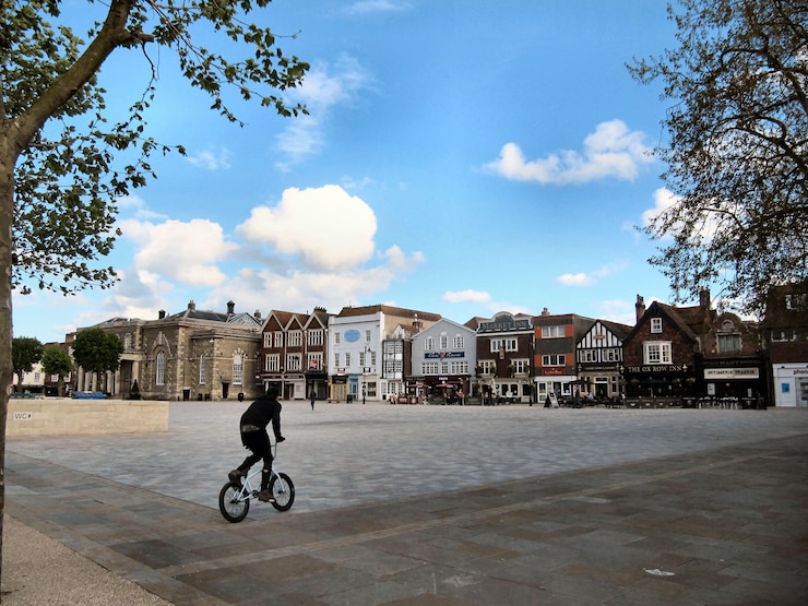 Fotoğraf woman walking on sidewalk against cloudy sky