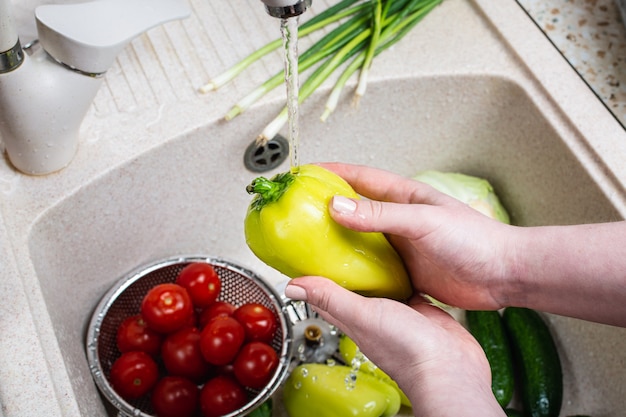 woman washing fresh vegetables