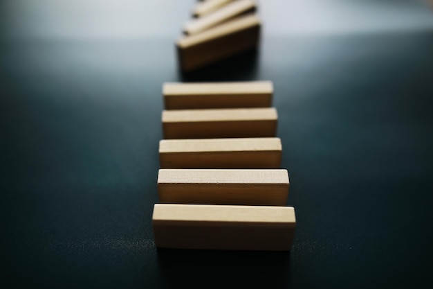 Yakın çekim, sıralı kalın domino tahta bloğu düşmeyi durduruyor, krizde istikrarlı olun, iş çözümü konsepti